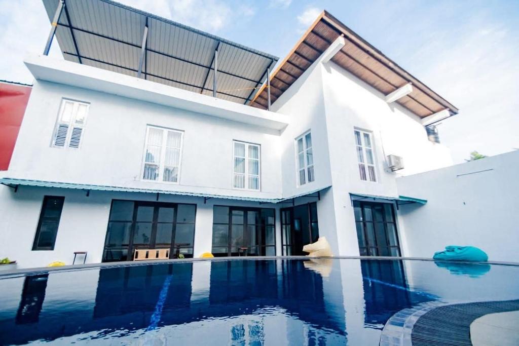 a house with a swimming pool in front of it at Hotel One Sixty in Dehiwala