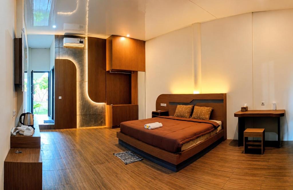 a large room with a bed and a table at Bale Bangket Homestay in Tetebatu