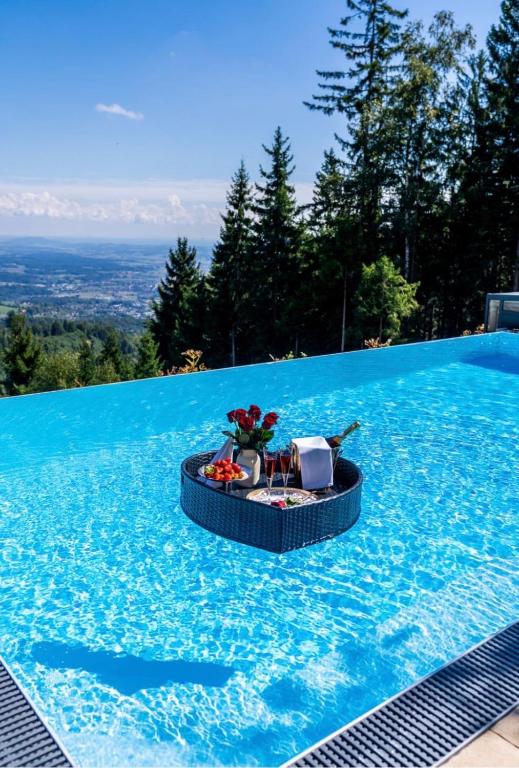 a swimming pool with a table in the middle of it at Schilcherland Chalet Südsteiermark in Trahütten
