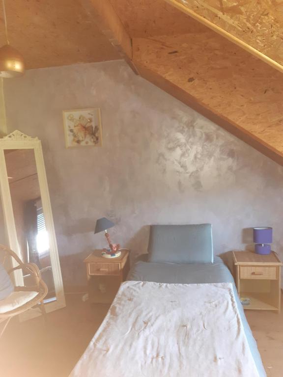 a bedroom with a bed and two tables and a mirror at Bien être la violette in Saint Malo