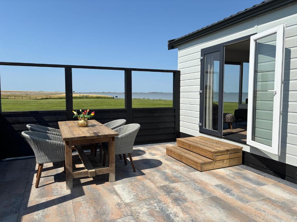 a patio with a table and chairs and a house at Chalet Wad'n Droom in Westerland