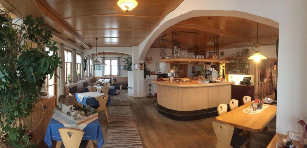 ein Zugzimmer mit einer Küche und einer Bar in der Unterkunft Wirtshaus zum Wiesejaggl in Kaunerberg