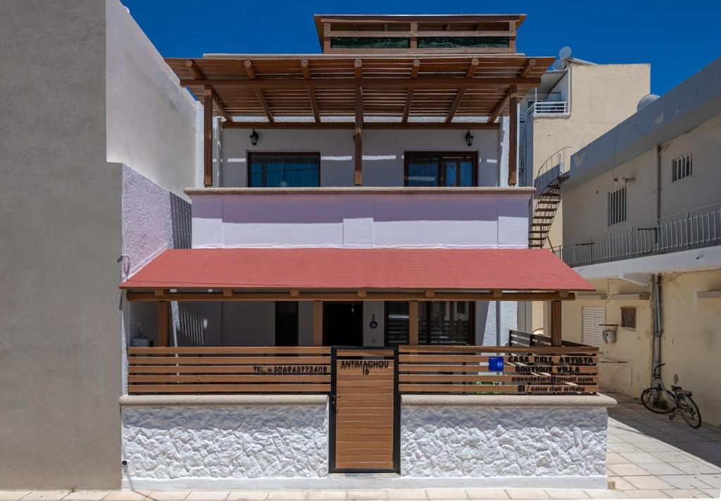 a house with a red awning on the side of it at Casa Dell Artista with private jacuzzi in Kos
