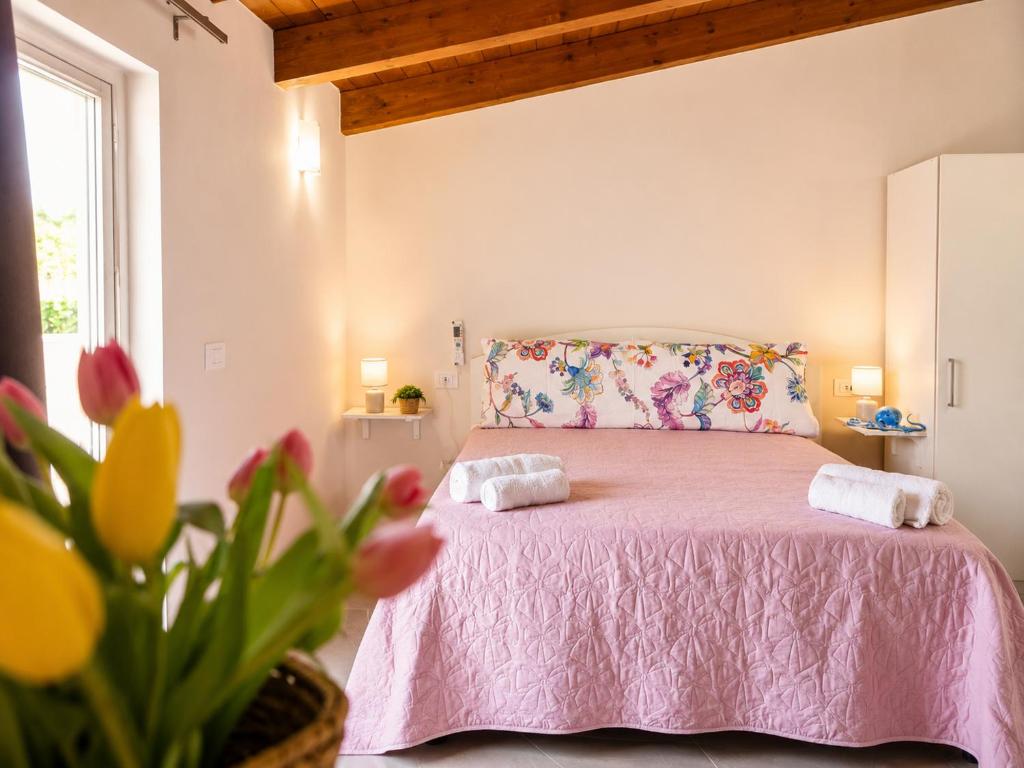 a bedroom with a pink bed with two pillows at Il Sogno di Ulisse in Le Castella
