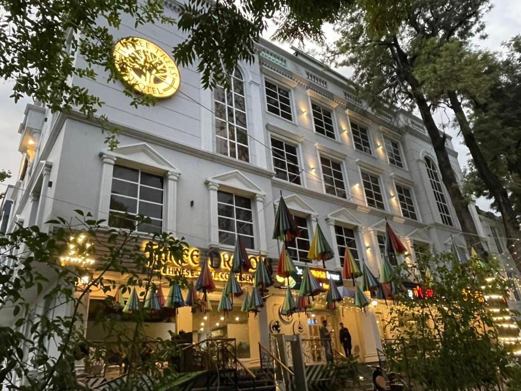 a building with a large clock on the side of it at Three Trees Hotel Islamabad in Islamabad