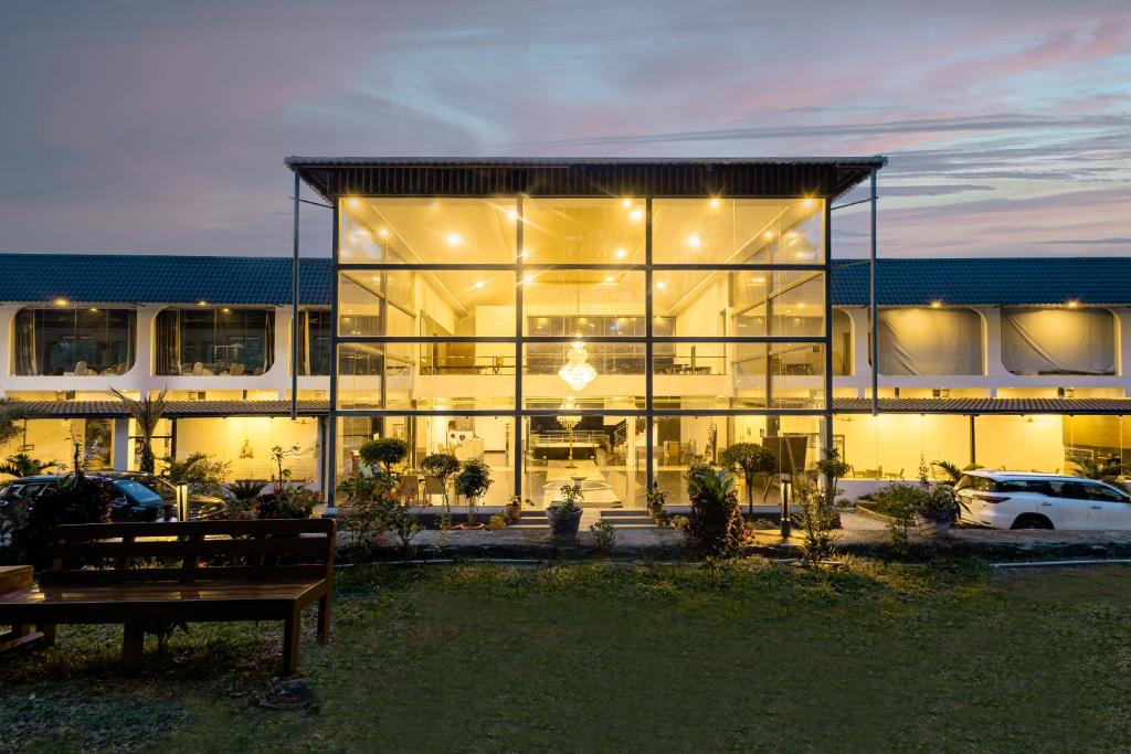 a large glass building with a bench in front of it at Mainland Resorts & Spa by Kolaahalam in Yercaud
