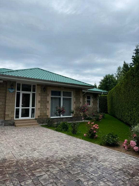 a house with a green roof and a yard at Карвен коттедж in Bulan Sogottuu