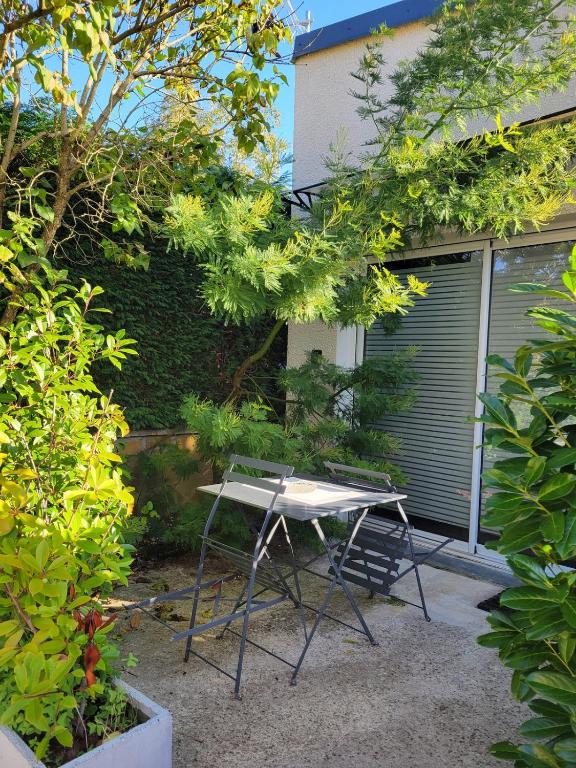 a picnic table and a chair in a garden at Studio cosy Climatisation, terrasse privée, parking devant la maison in Nevers