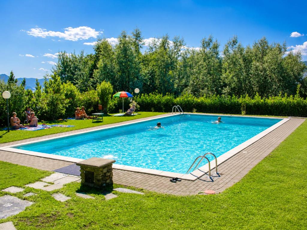 a pool with people swimming in it in a yard at Residenza Paradiso in Agra