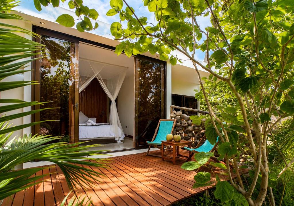 a room with a deck with a bed and a bedroom at CosyBe Villas in Praia do Tofo