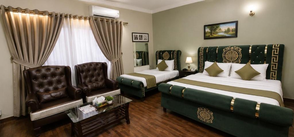 a hotel room with two beds and a couch at F-7 Guest House, Islamabad in Islamabad