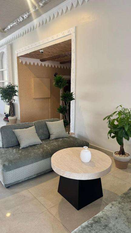 a living room with a couch and a table at منتجع اغصان الشفا in Ash Shafa