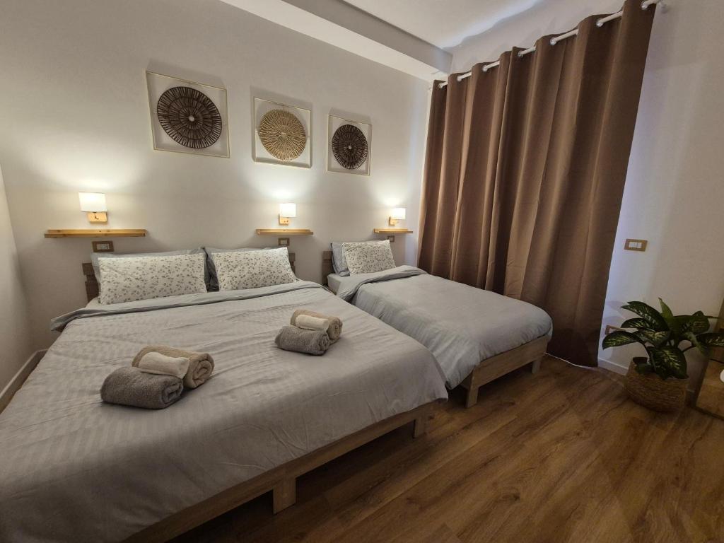 zwei Betten in einem Schlafzimmer mit zwei Handtüchern darauf in der Unterkunft Civico181 in Cisterna di Latina
