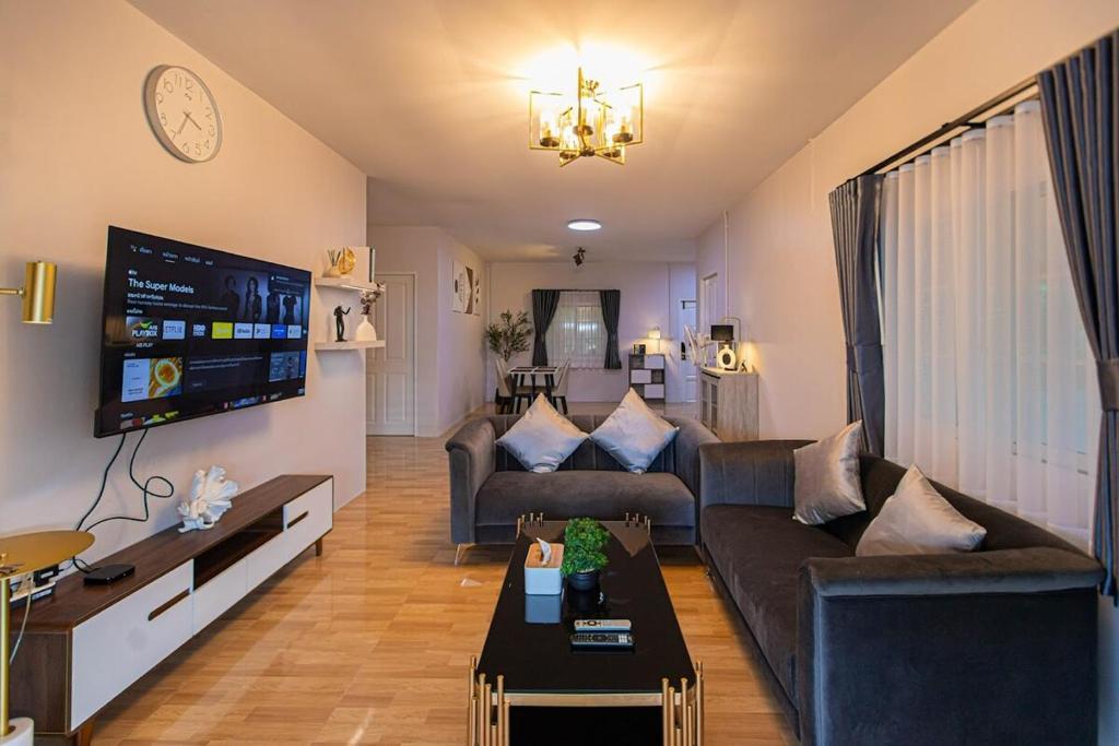 a living room with a couch and a tv at The Comfy House Prachuap in Sathani Rot Fai