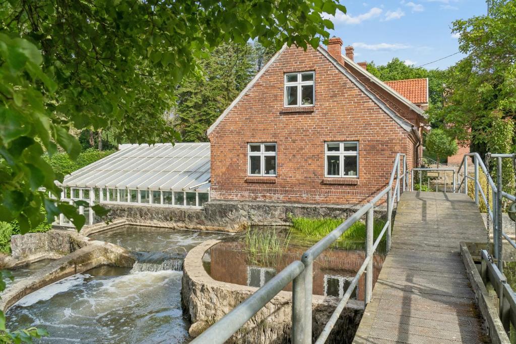 a house with a pond in front of a building at Charming 45 M House In Peaceful Setting in Gelsted