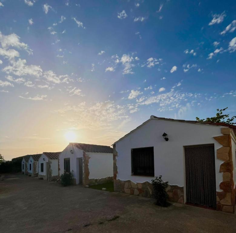 a group of buildings with the sunset in the background at Aldeana Rural in El Cubillo