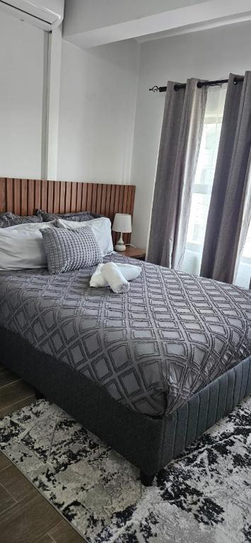 a large bed in a bedroom with a window at Sonrise Stays in Gaborone