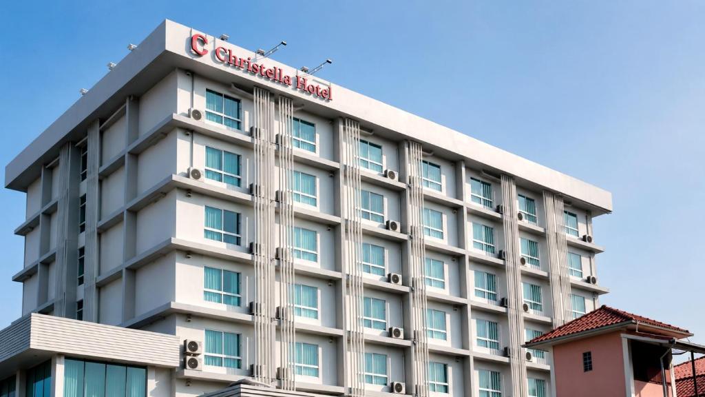 a hotel building with a sign on top of it at Christella Hotel Laemchabang in Si Racha