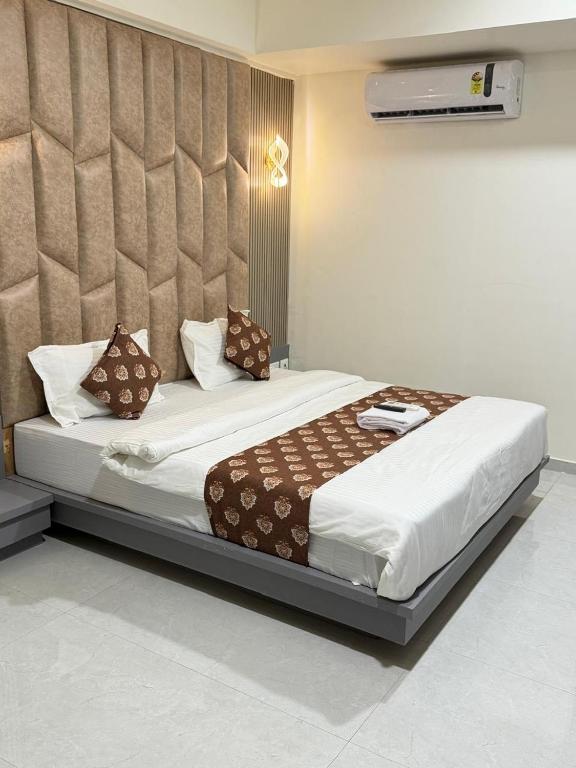 a bedroom with a large bed in a room at Hotel Runway in Vadodara