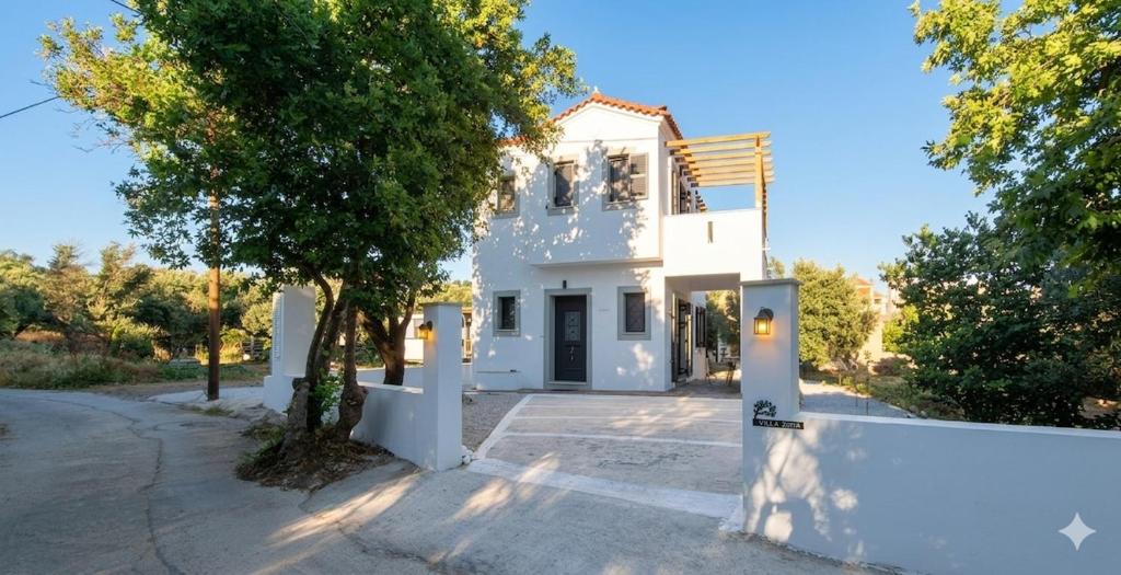 a white house with a tree in front of it at VILLA MIPA Samos in Kámpos
