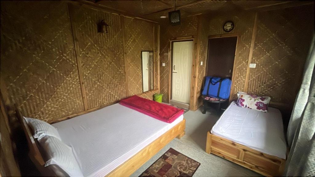 a small room with two beds and a blue backpack at Rangdu Homestay in Darjeeling