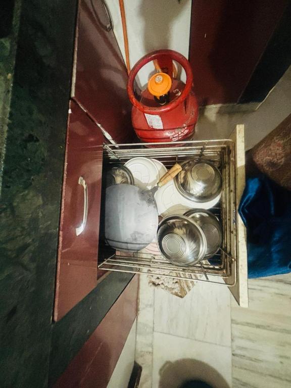 a drawer in a cabinet with pots and pans at Lara Homestay 2bhk in Secunderabad