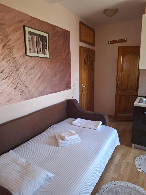 a bedroom with a bed with two towels on it at Apartmani Lazić No 4 in Gracanica