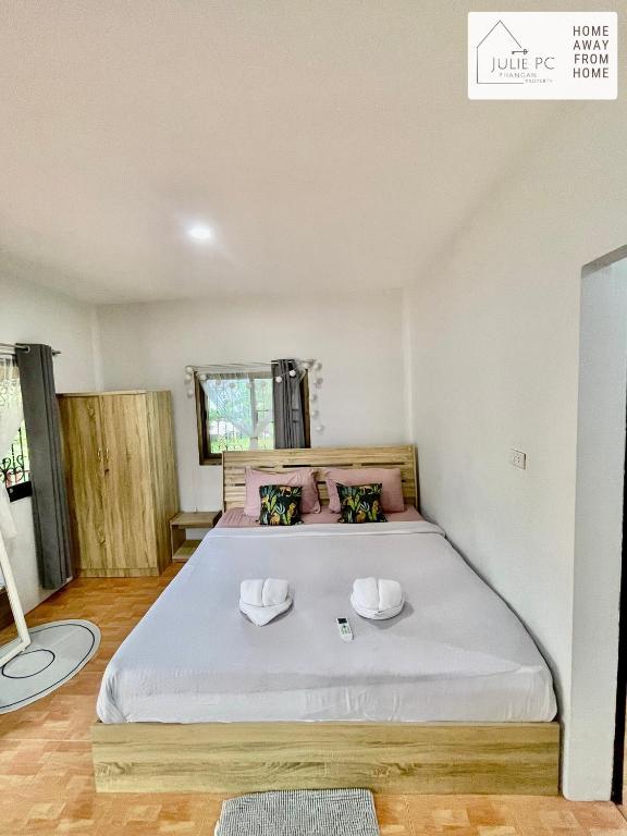 a bedroom with a bed with two hats on it at Temple House by Julie PC in Ko Phangan