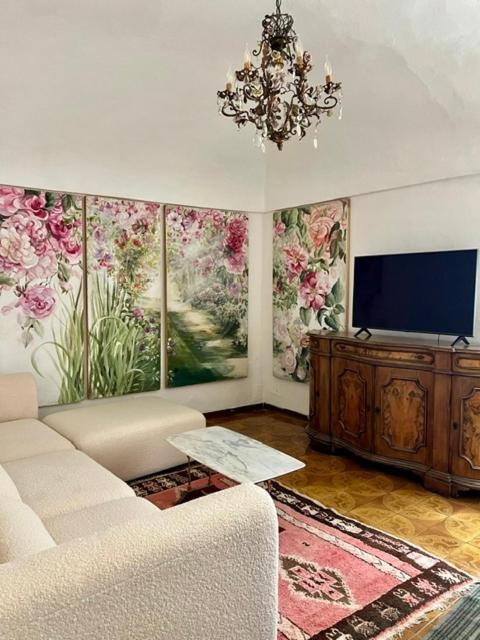 a living room with a couch and a flat screen tv at Historic Center Cottage Style Apartment in Pontremoli