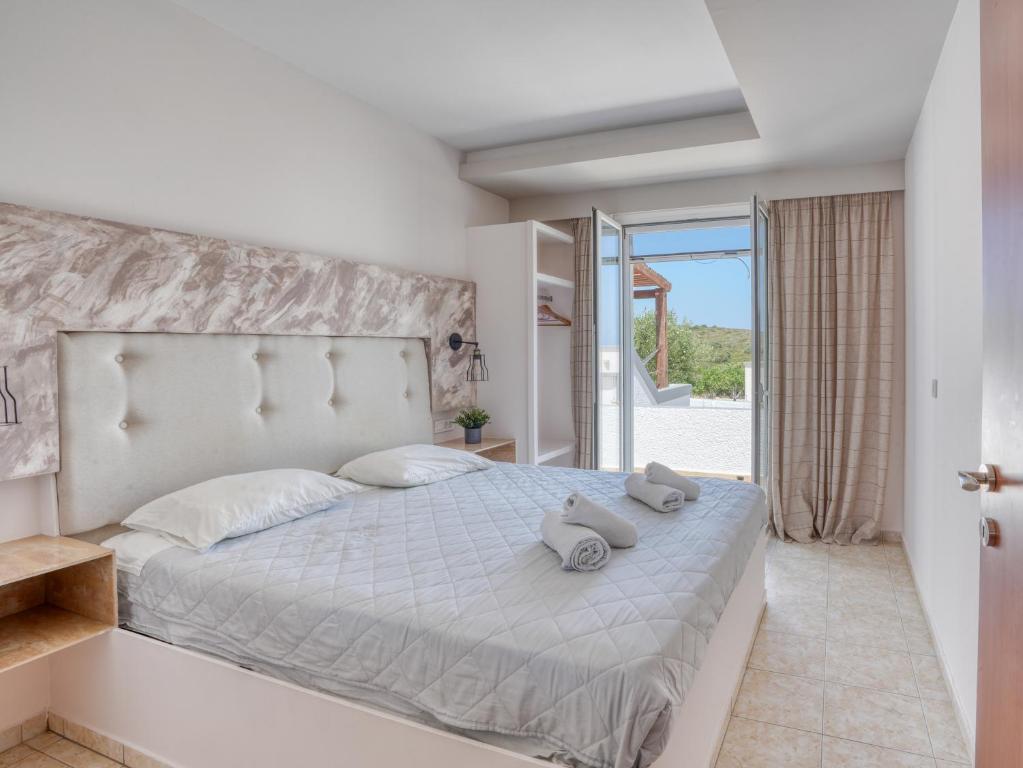 a bedroom with a bed with two stuffed animals on it at Kochylari Apartments in Kefalos