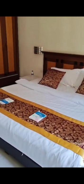 two beds in a hotel room with at Homestay frandy beach villa in Batu Ferringhi