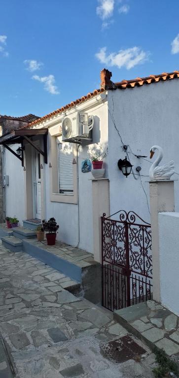 a white house with a gate in front of it at Angelina's House in Glossa