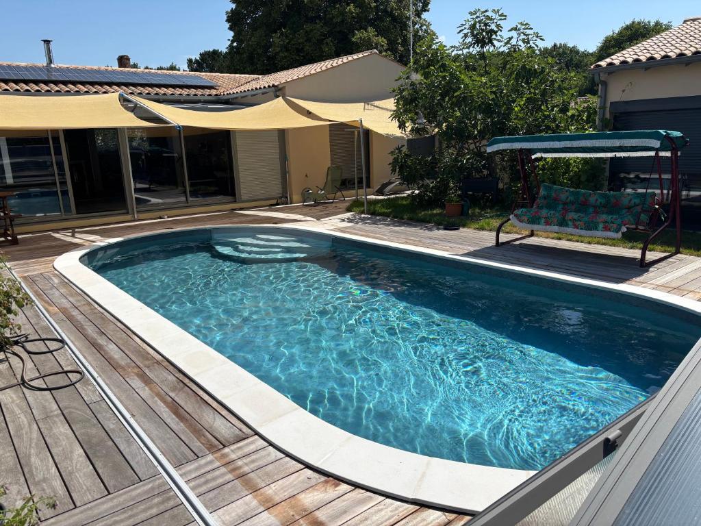 a swimming pool on a deck with a chair in it at La perle in Les Mathes