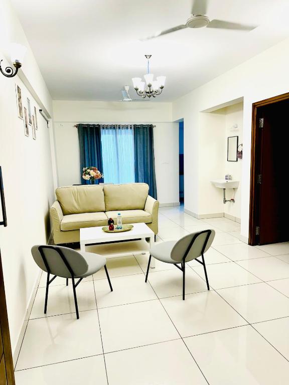 a living room with a couch and a table and chairs at North scape 104 in Bangalore