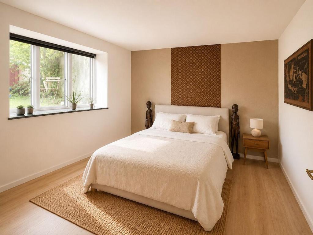 ein Schlafzimmer mit einem großen Bett und einem Fenster in der Unterkunft Java Themed flat near Zoo in Aalborg