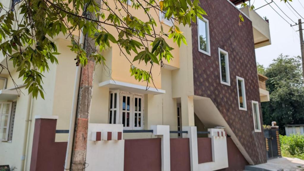 a house with a white fence in front of it at Janani service apartment in Kushālnagar
