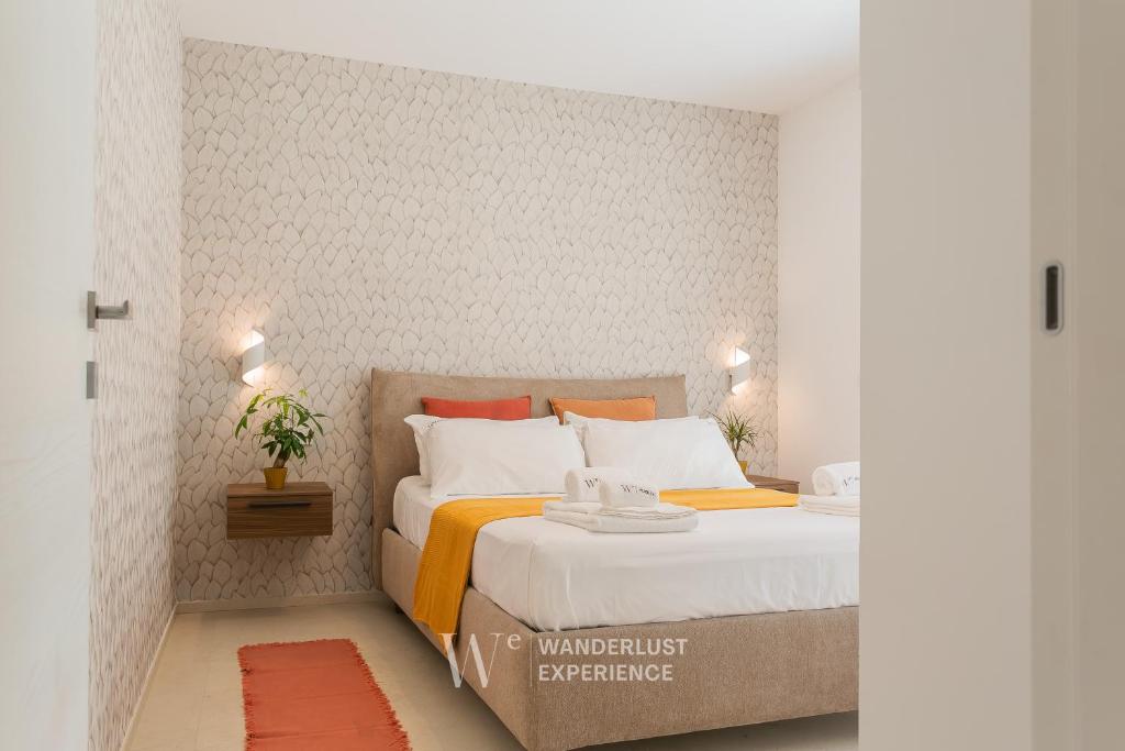 a bedroom with a bed with orange and white pillows at Wanderlust Experience Villa Milly in Giovinazzo