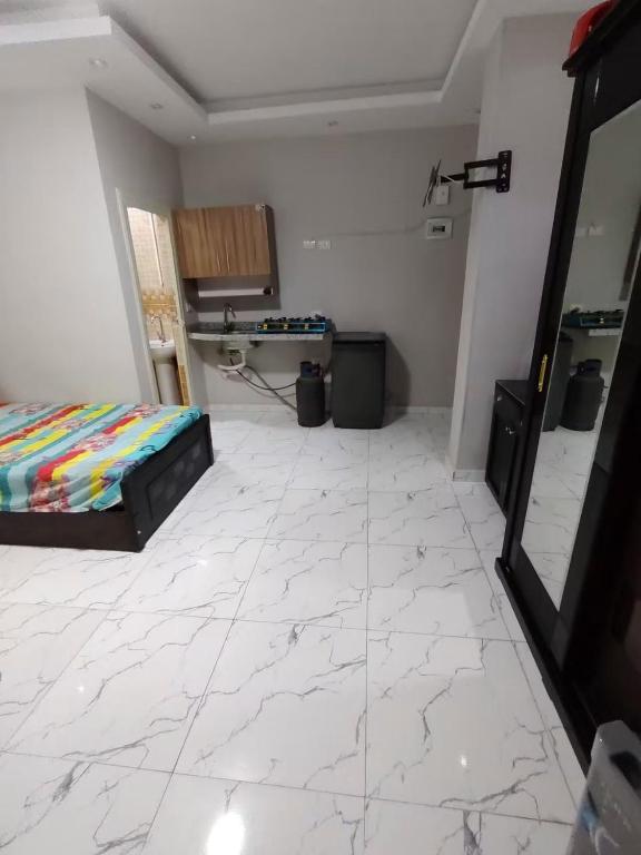 a bedroom with a bed and a desk in a room at Rahej home in Bandar al Manşūrah
