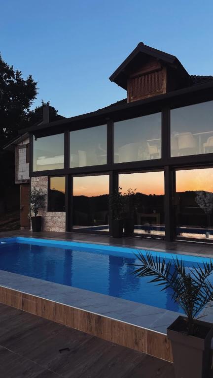 a large building with a swimming pool in front of it at Apartmani Nase brdo in Guča