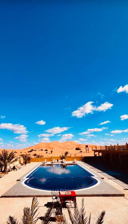 a swimming pool in the middle of the desert at Les Roses Des Dunes in Merzouga