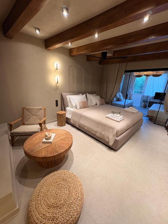 a large bedroom with a bed and a table at Olive Grove Retreat Paxos in Vlachopoulátika