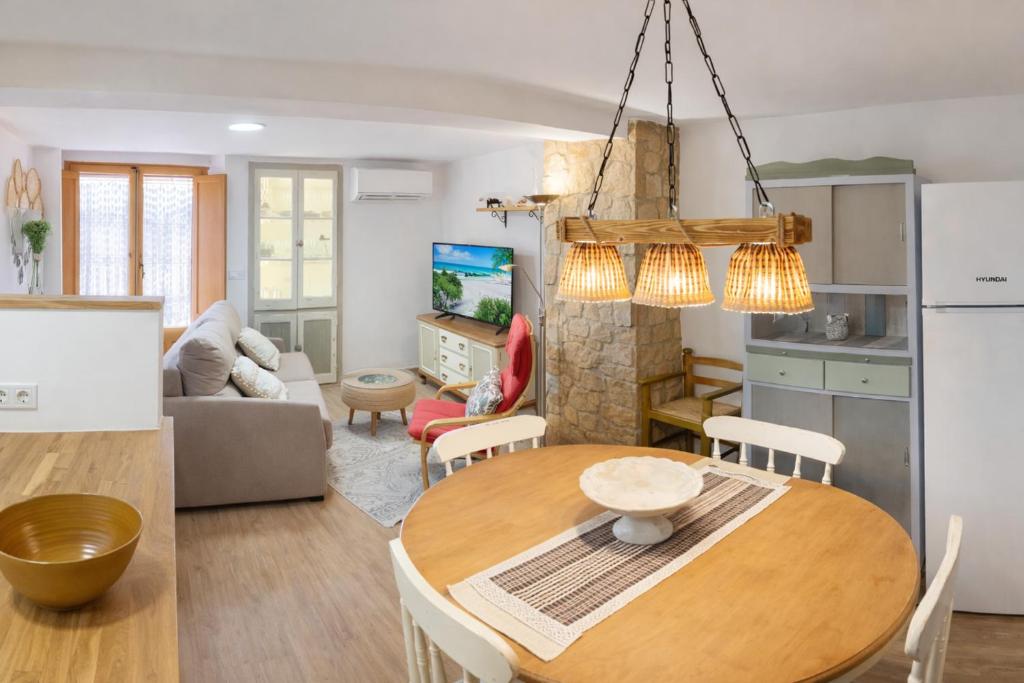 a kitchen and living room with a table and chairs at Cal Folquer in Alentorn