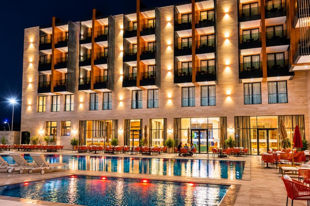 a hotel with a swimming pool in front of a building at Hotel Deauville El jadida in El Jadida