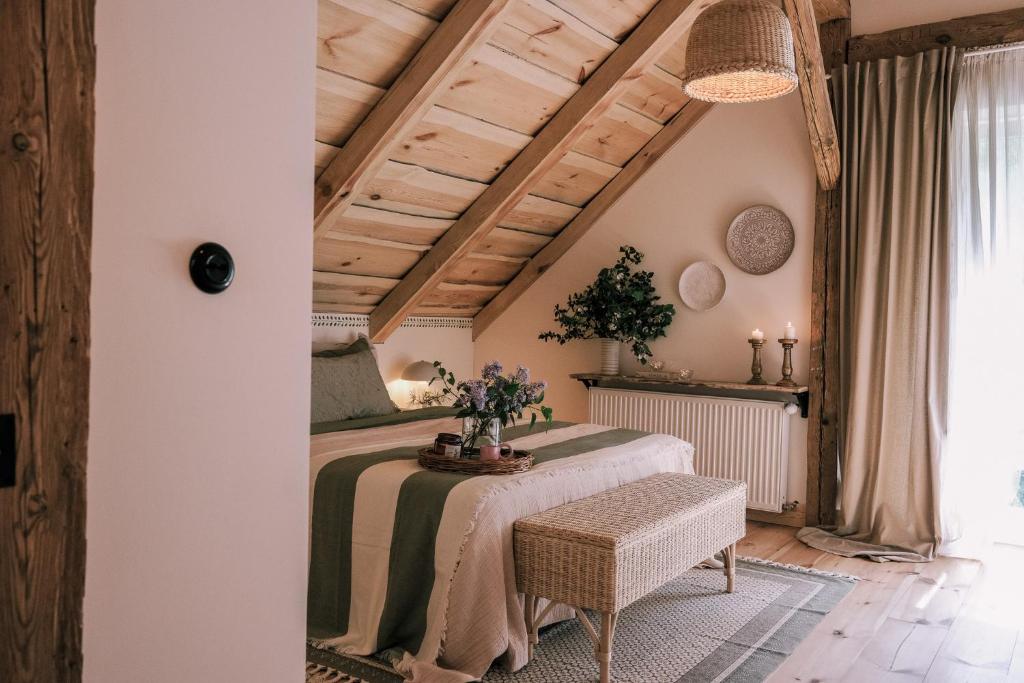 a bedroom with a bed and a table with flowers on it at Tajna Bazia in Nidzica