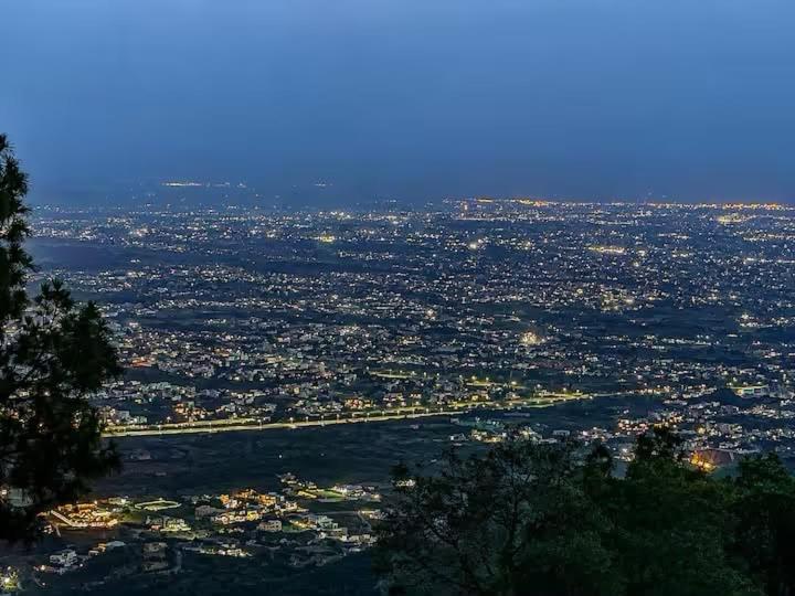 a view of a city from the top of a hill at Baam-E-Noor , Pine Tree Resort , Margalla Hills Islamabad in Harīpur