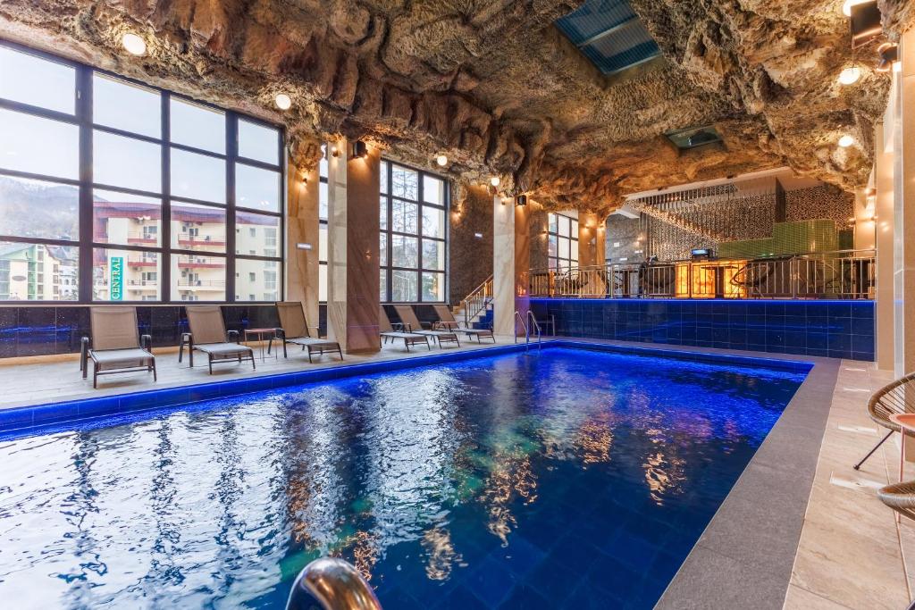 a swimming pool in a building with windows at Imperial Hotel&Spa - Baile Olanesti in Băile Olăneşti