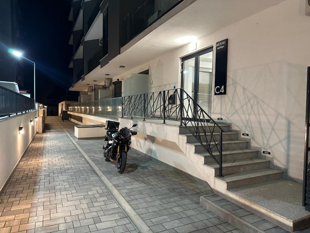a motorcycle parked outside of a building at night at Apartament Meraki Resort&Spa in Năvodari