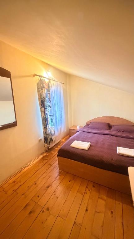 a bedroom with a bed and a wooden floor at Stara Praha Loft Rooms in Uzhhorod