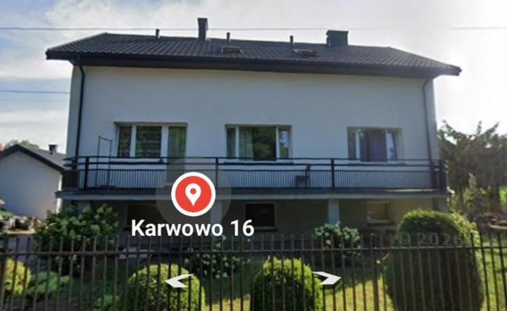 a house with a sign in front of a fence at Pod Lasem in Altanka