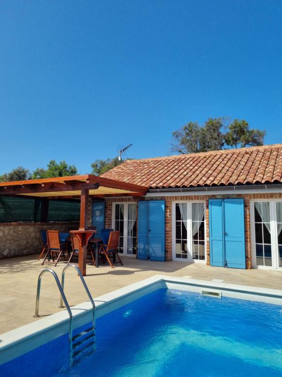 a house with a swimming pool and a patio at Vila s bazenom Mavrinac in Nerezine